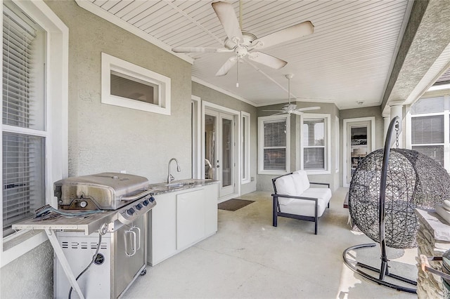 view of patio featuring ceiling fan, an outdoor kitchen, area for grilling, and sink