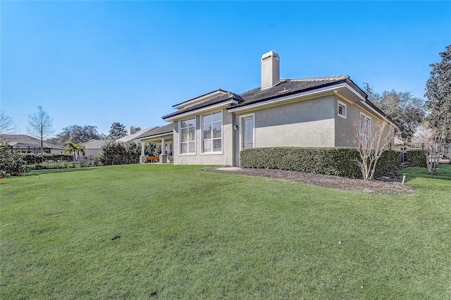 rear view of property with a yard