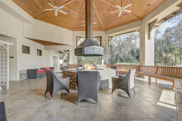 view of patio featuring ceiling fan, an outdoor fire pit, and a gazebo