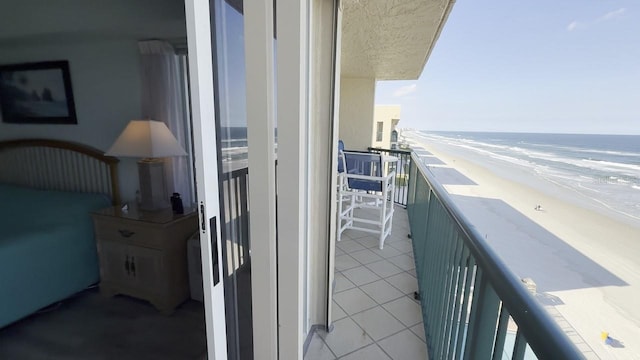 balcony featuring a water view and a beach view