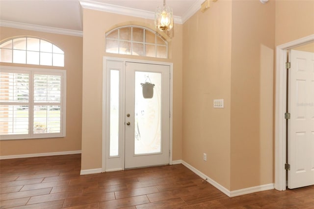 foyer featuring dark wood-type flooring, crown molding, and a chandelier