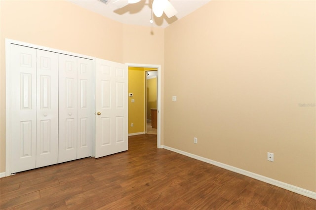 unfurnished bedroom featuring a towering ceiling, hardwood / wood-style floors, and ceiling fan