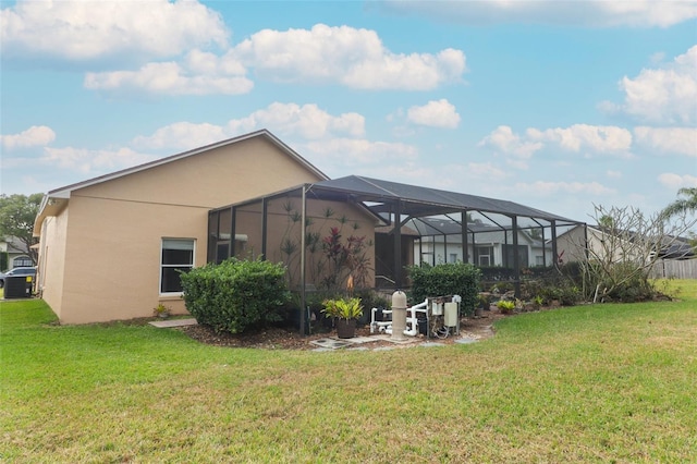 back of house with a yard, central AC, and glass enclosure