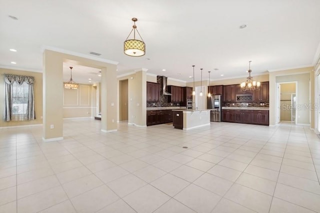 kitchen featuring decorative light fixtures, light tile patterned floors, a kitchen island, decorative backsplash, and wall chimney range hood