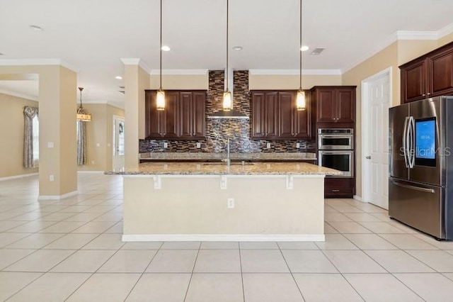 kitchen featuring pendant lighting, appliances with stainless steel finishes, and a center island with sink