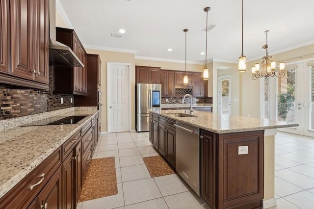 kitchen with sink, decorative light fixtures, stainless steel appliances, light stone countertops, and a kitchen island with sink