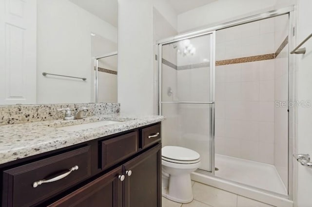 bathroom featuring tile patterned flooring, vanity, walk in shower, and toilet