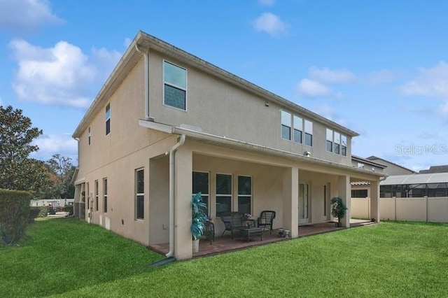 back of property with a patio and a lawn