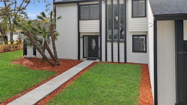 entrance to property featuring a lawn