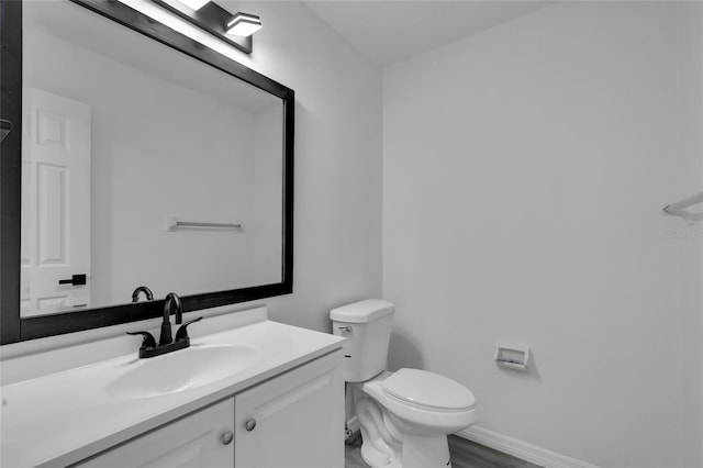 bathroom with hardwood / wood-style floors, toilet, and vanity