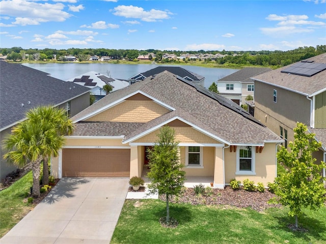 craftsman-style home with a garage, a water view, and a front lawn