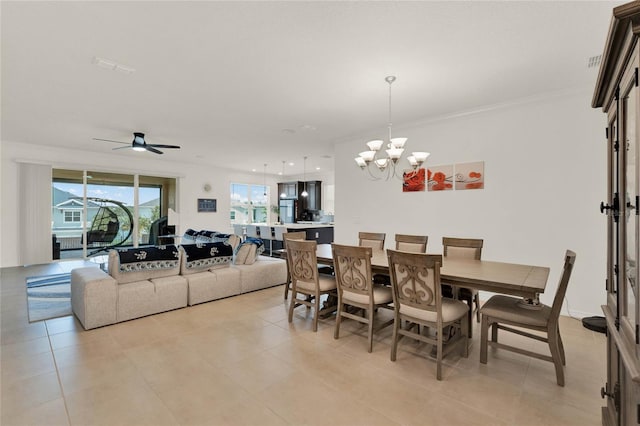 tiled dining space with ceiling fan with notable chandelier and ornamental molding