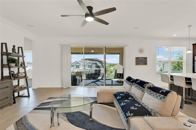 tiled living room featuring ornamental molding, ceiling fan, and plenty of natural light