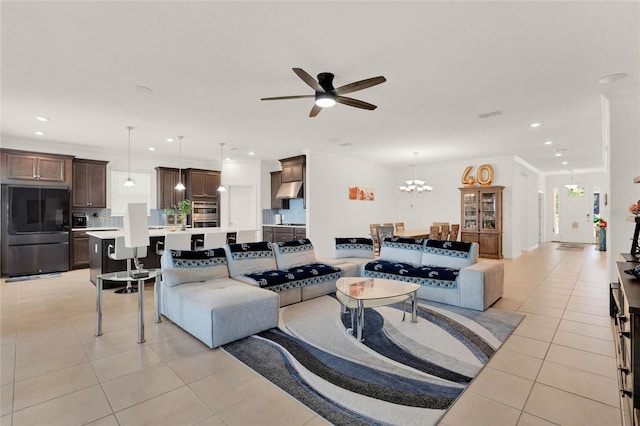 living room with ceiling fan with notable chandelier, light tile patterned floors, and crown molding