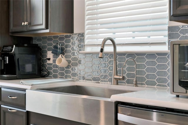 kitchen featuring stainless steel dishwasher, decorative backsplash, sink, and dark brown cabinets