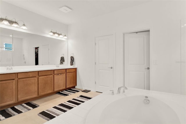 bathroom featuring tile patterned floors, a tub to relax in, and vanity