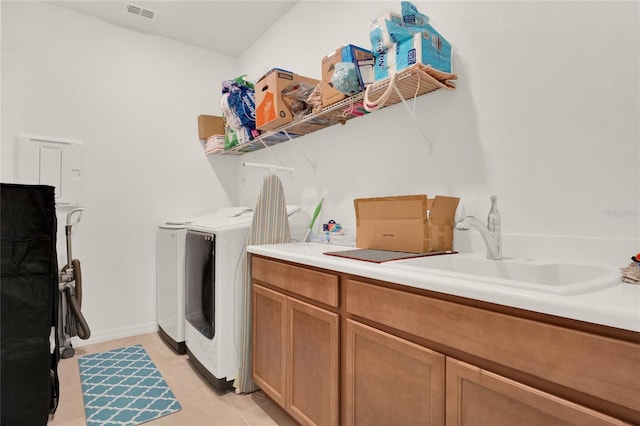 washroom with sink, washer and clothes dryer, light tile patterned flooring, and cabinets