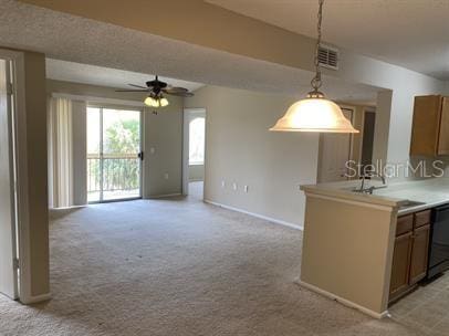 kitchen featuring ceiling fan, light colored carpet, dishwasher, sink, and hanging light fixtures