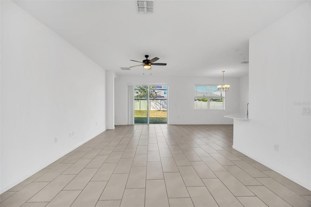 spare room with ceiling fan with notable chandelier and light tile patterned floors