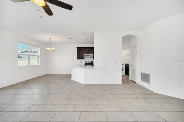 unfurnished living room with ceiling fan with notable chandelier, washer / clothes dryer, light tile patterned floors, and sink