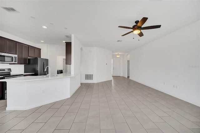 kitchen featuring stainless steel appliances, light tile patterned floors, ceiling fan, dark brown cabinets, and sink