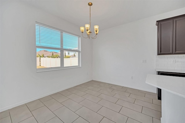 unfurnished dining area featuring an inviting chandelier and light tile patterned floors