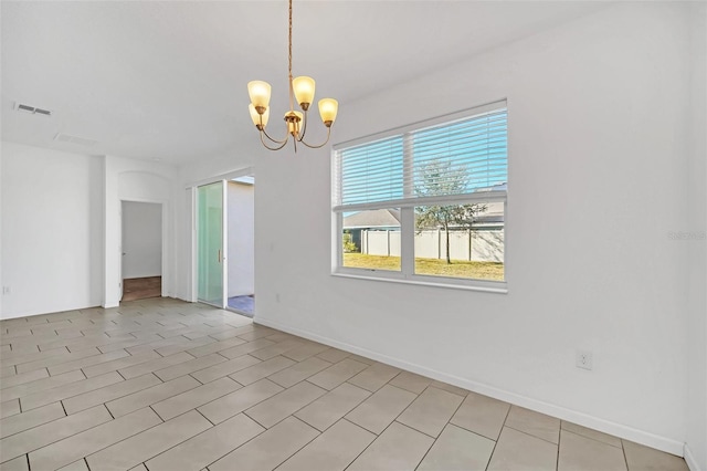 empty room featuring a chandelier and light tile patterned floors