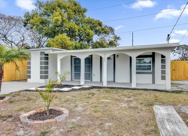 ranch-style house featuring covered porch and a front lawn