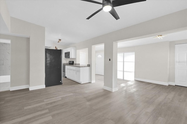 unfurnished living room with ceiling fan and light hardwood / wood-style flooring