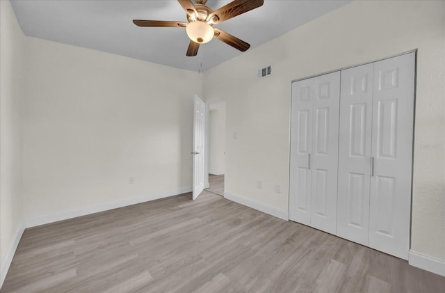 unfurnished bedroom with ceiling fan, a closet, and light hardwood / wood-style floors