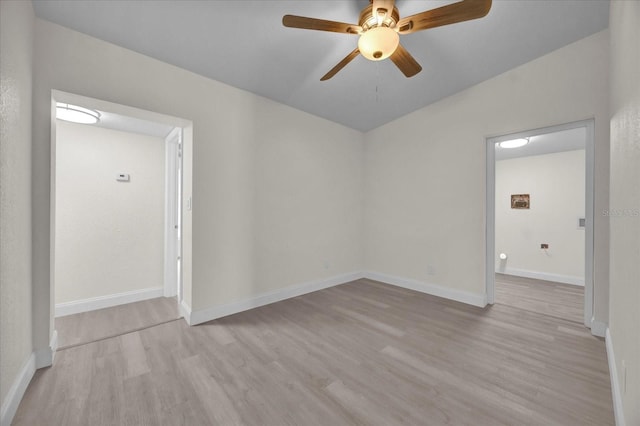 empty room with ceiling fan, light wood-type flooring, and lofted ceiling