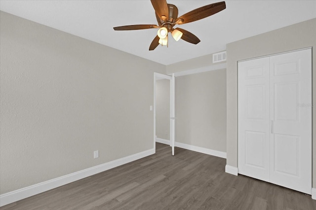 unfurnished bedroom with ceiling fan, a closet, and dark hardwood / wood-style flooring