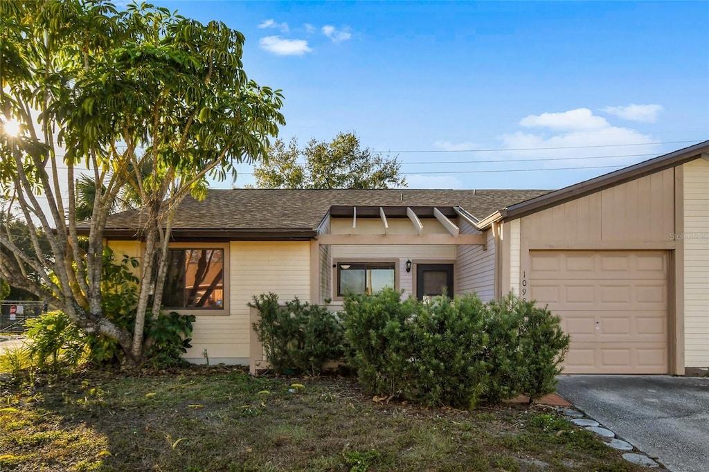 single story home with a garage and a front lawn