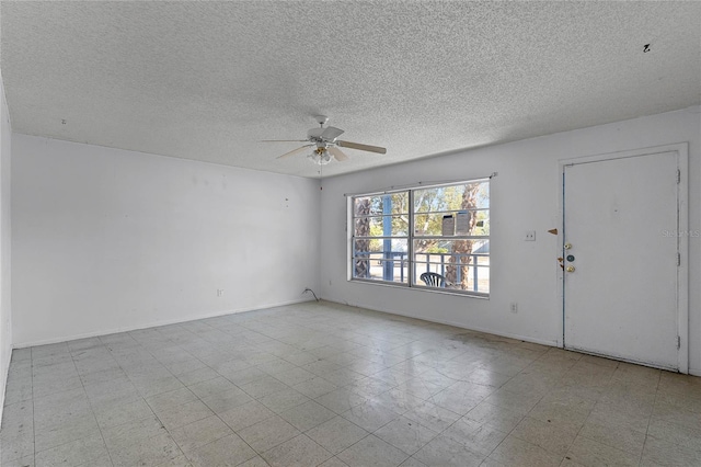 empty room with a textured ceiling and ceiling fan