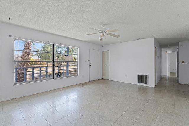 empty room with a textured ceiling and ceiling fan