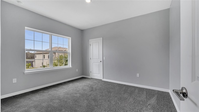 spare room featuring dark carpet