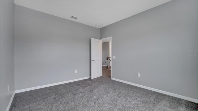 spare room with dark colored carpet