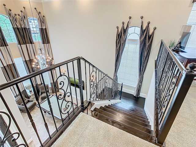 stairs with a chandelier and hardwood / wood-style flooring