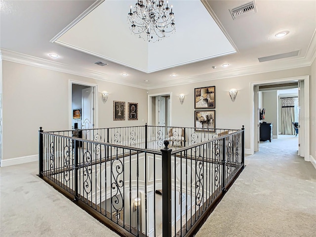 hallway with a chandelier, crown molding, and light carpet