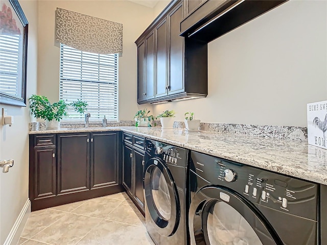 clothes washing area featuring sink, light tile patterned floors, cabinets, and independent washer and dryer