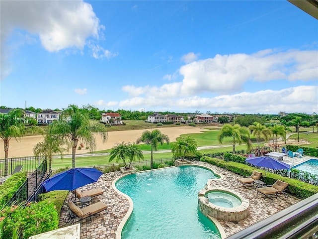 view of swimming pool featuring pool water feature, a patio area, and an in ground hot tub