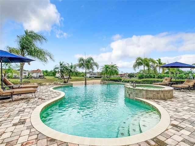 view of pool with pool water feature, an in ground hot tub, and a patio area