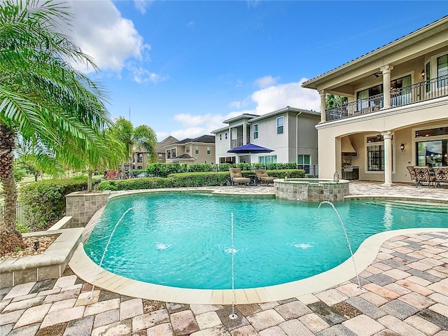 view of swimming pool featuring ceiling fan, a patio, pool water feature, and an in ground hot tub