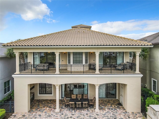 rear view of house with a balcony and a patio area