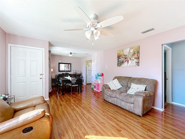 living room featuring hardwood / wood-style floors and ceiling fan