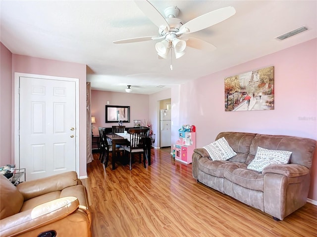 living room featuring light wood-type flooring and ceiling fan