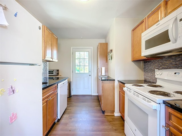 kitchen with white appliances and dark hardwood / wood-style floors