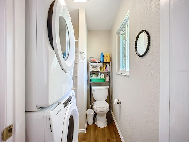 bathroom featuring toilet, wood-type flooring, and stacked washer / drying machine