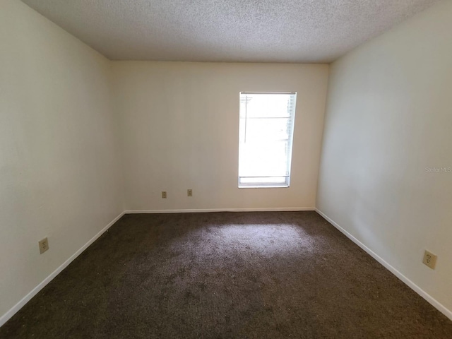 carpeted empty room featuring a textured ceiling