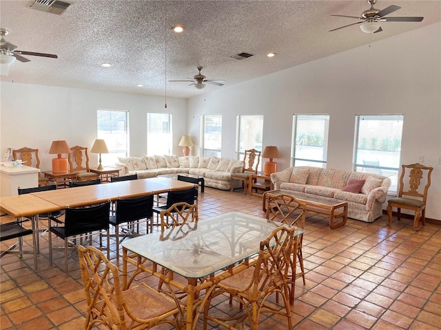 tiled dining room featuring high vaulted ceiling, a textured ceiling, and ceiling fan